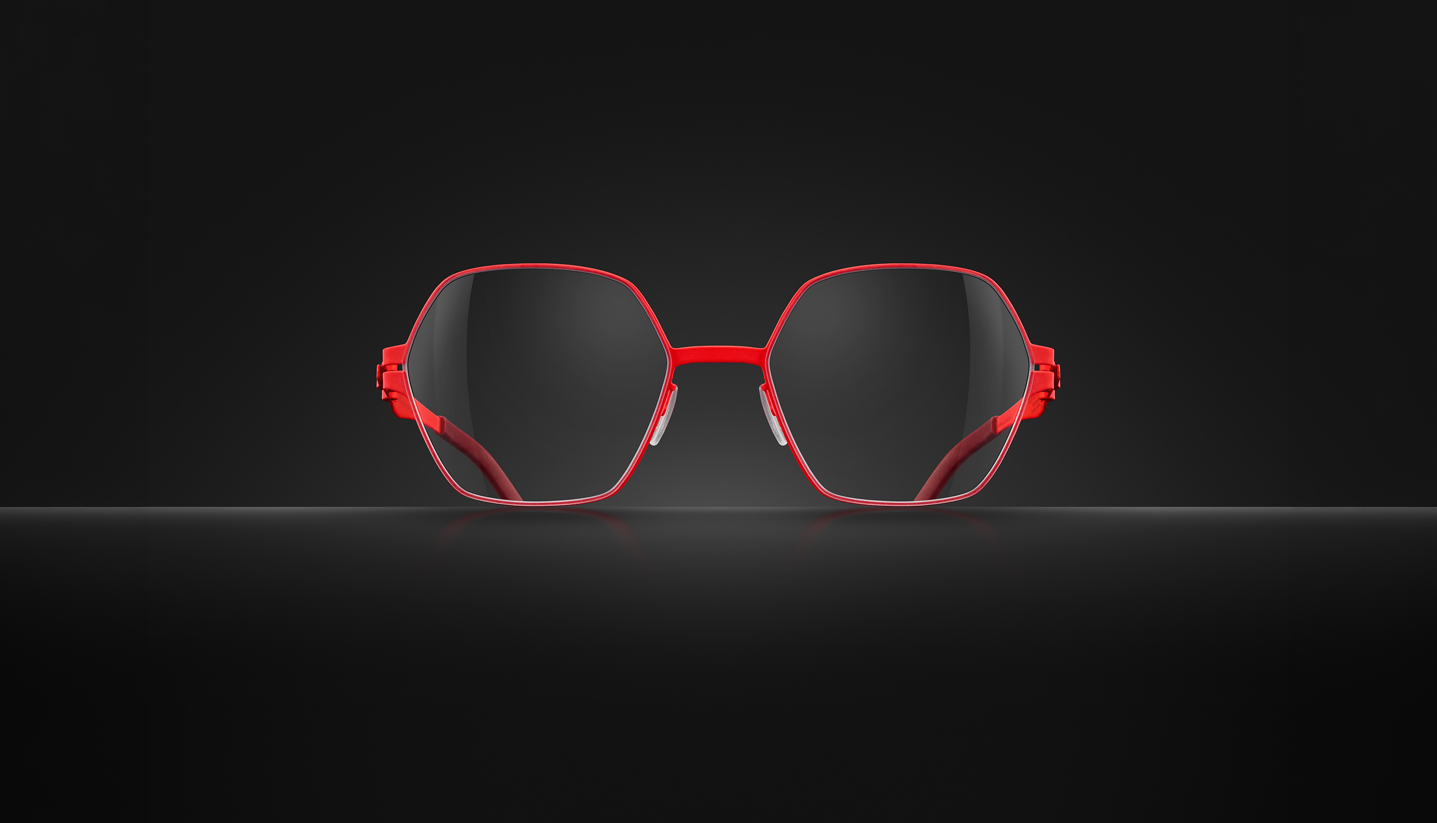 OVVO Optics red geometric optical glasses in a front-facing studio shot on a dark background