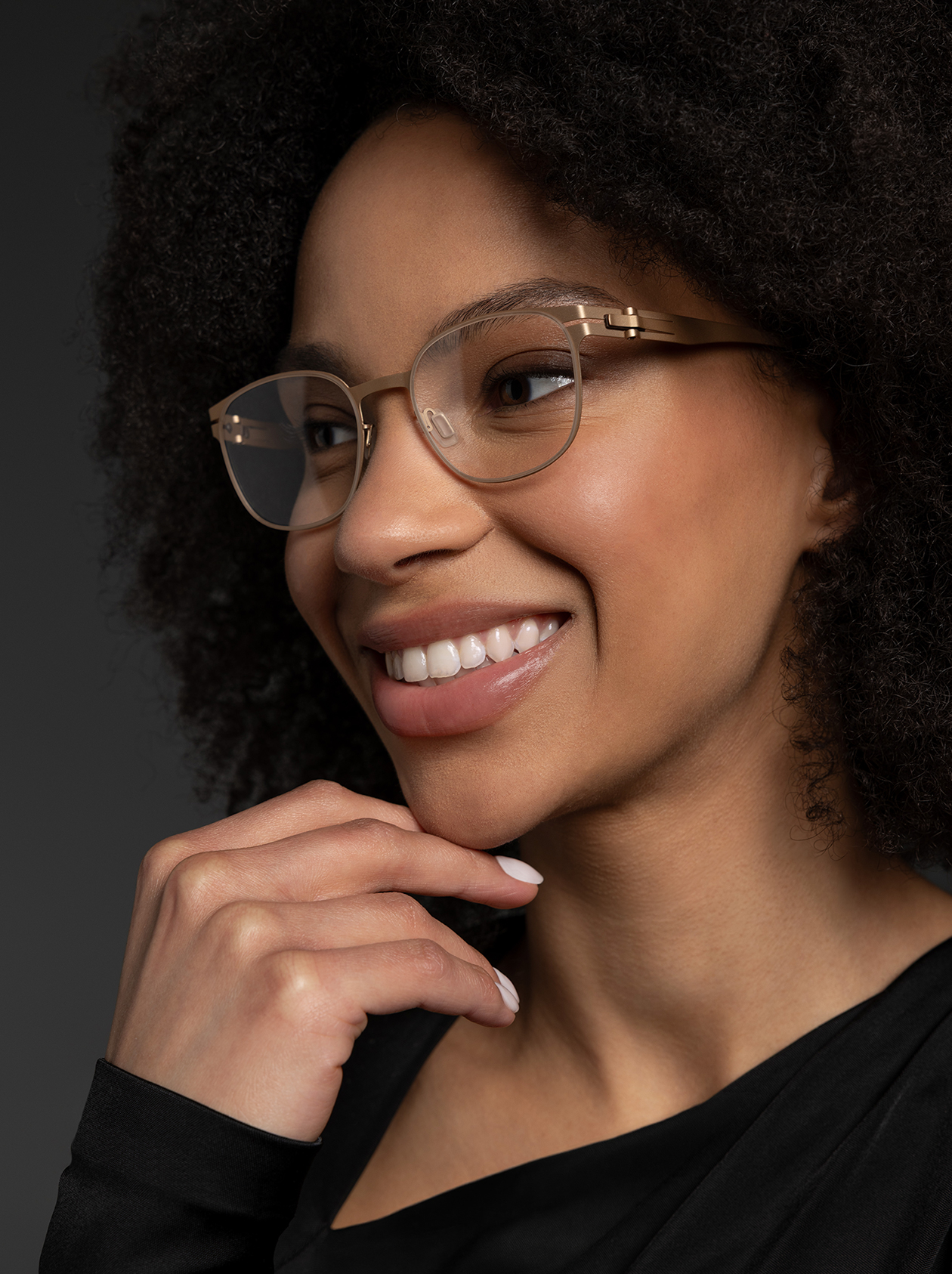 OVVO Optics close-up portrait of a smiling woman wearing translucent gold geometric eyeglasses