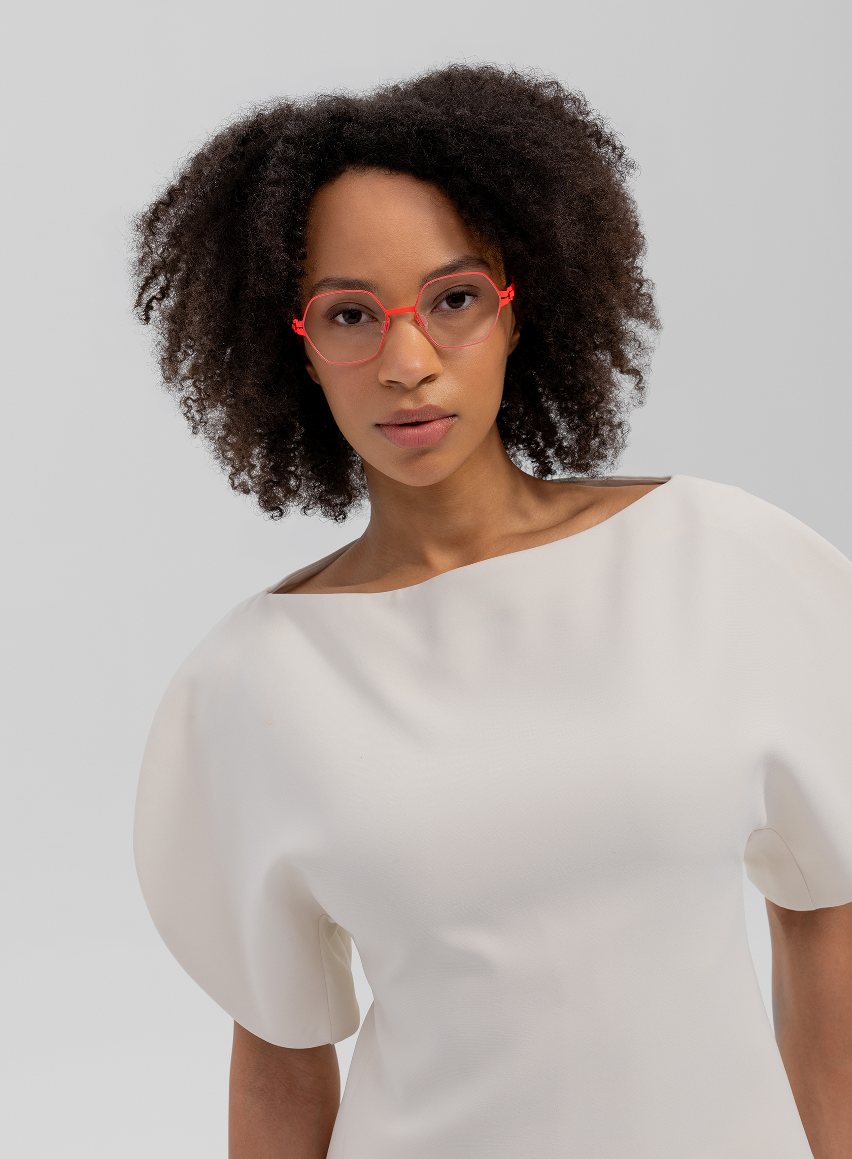 OVVO Optics portrait of a woman wearing red geometric optical glasses in a white top