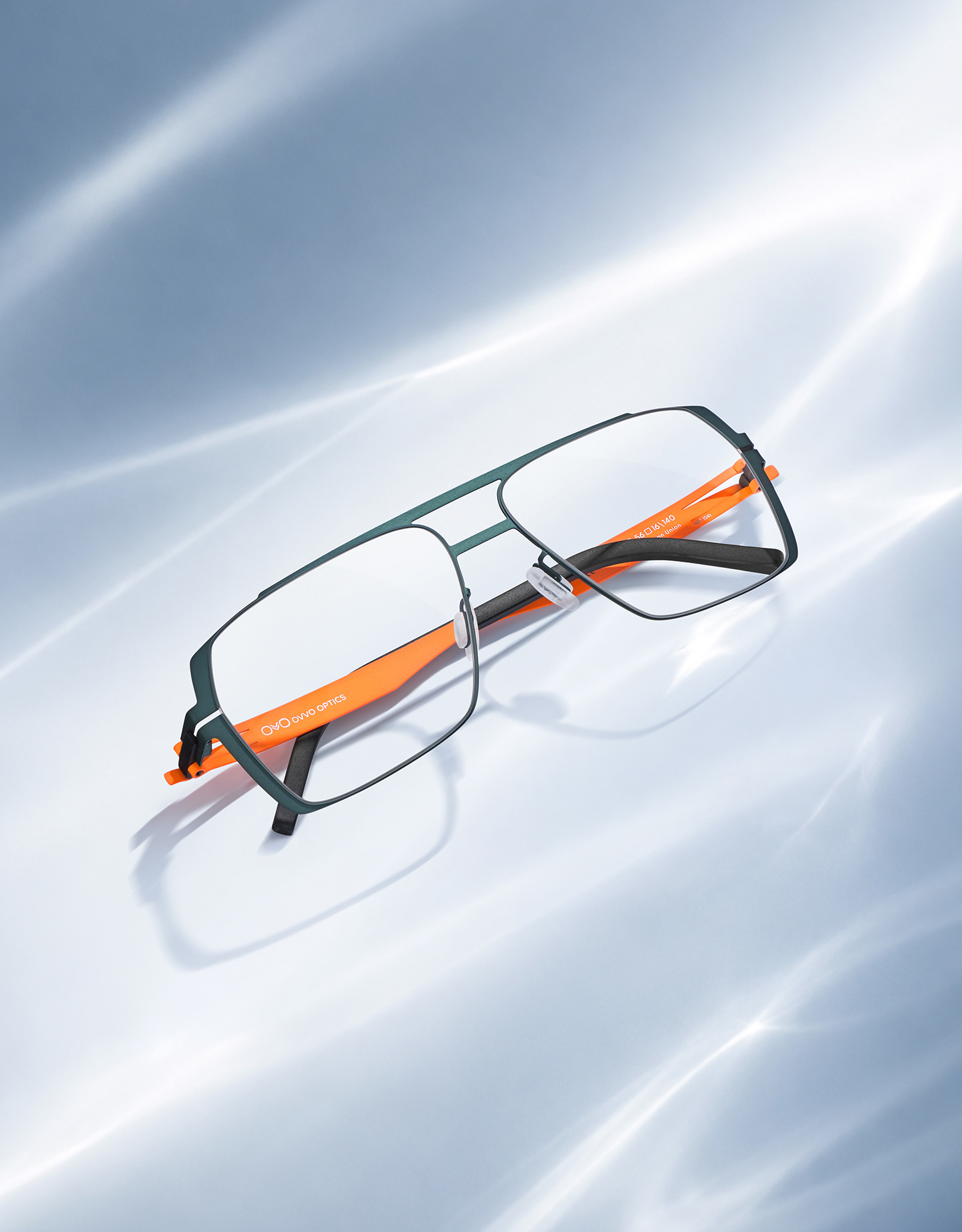 OVVO Optics green rectangular optical frame with orange temples in a studio product shot