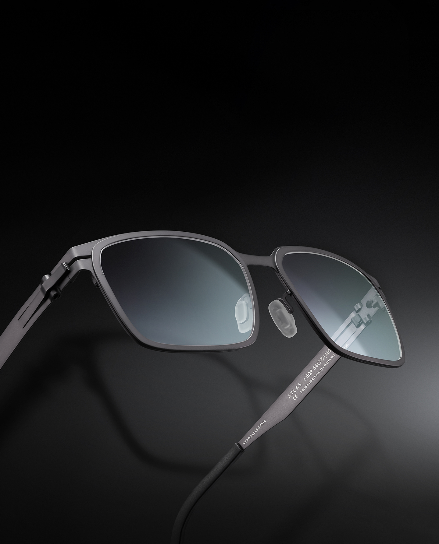 OVVO Optics Ti2 Expanded Atlas angular titanium sunglasses on a dark studio surface
