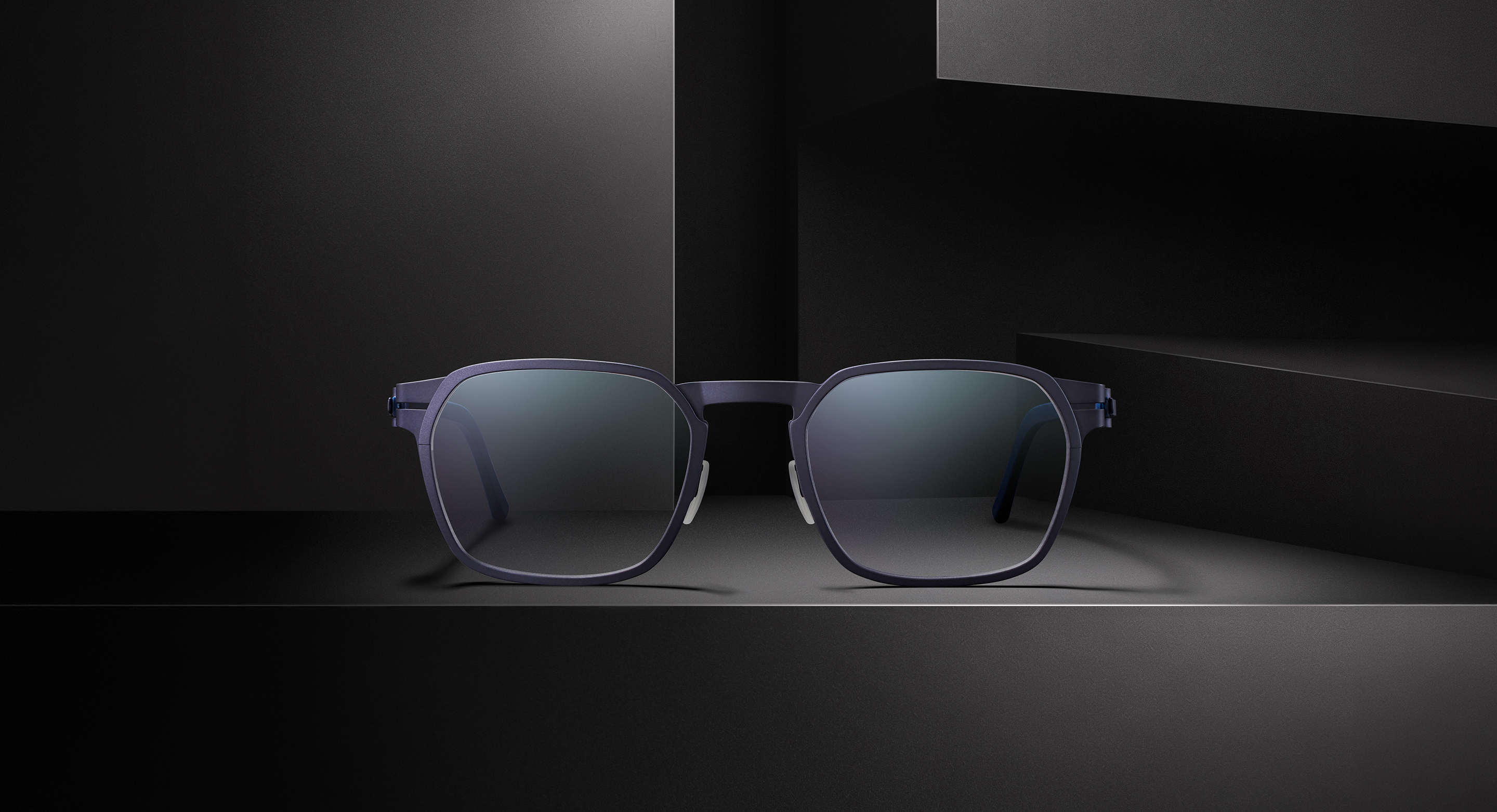 OVVO Optics Ti2 Expanded Atlas titanium sunglasses front view on a dark architectural set